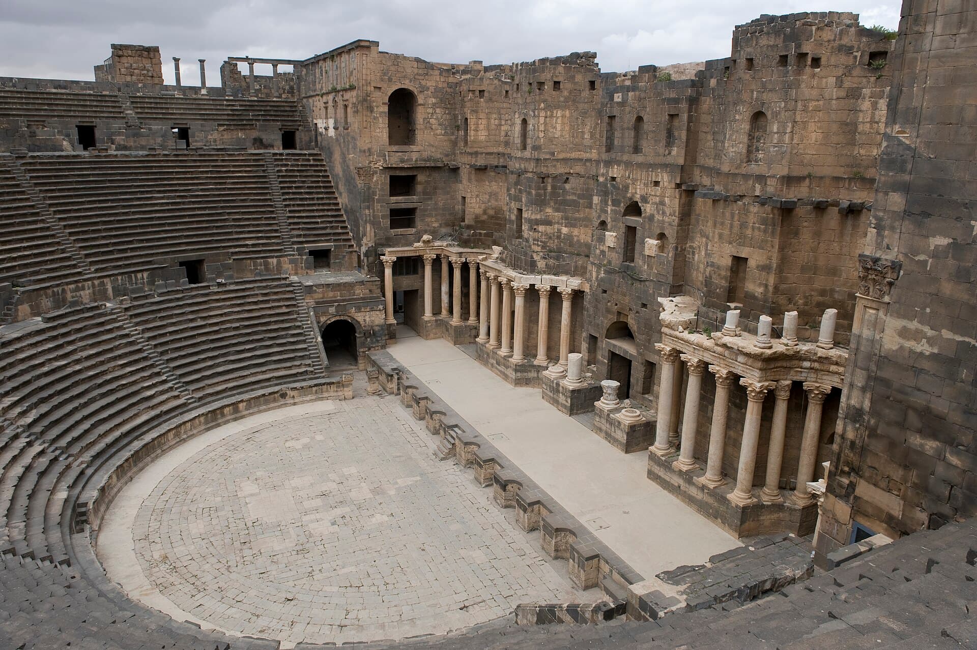 Busra Roma tiyatrosunun siyah bazalt oturma sıraları ve sütunlu sahne binası