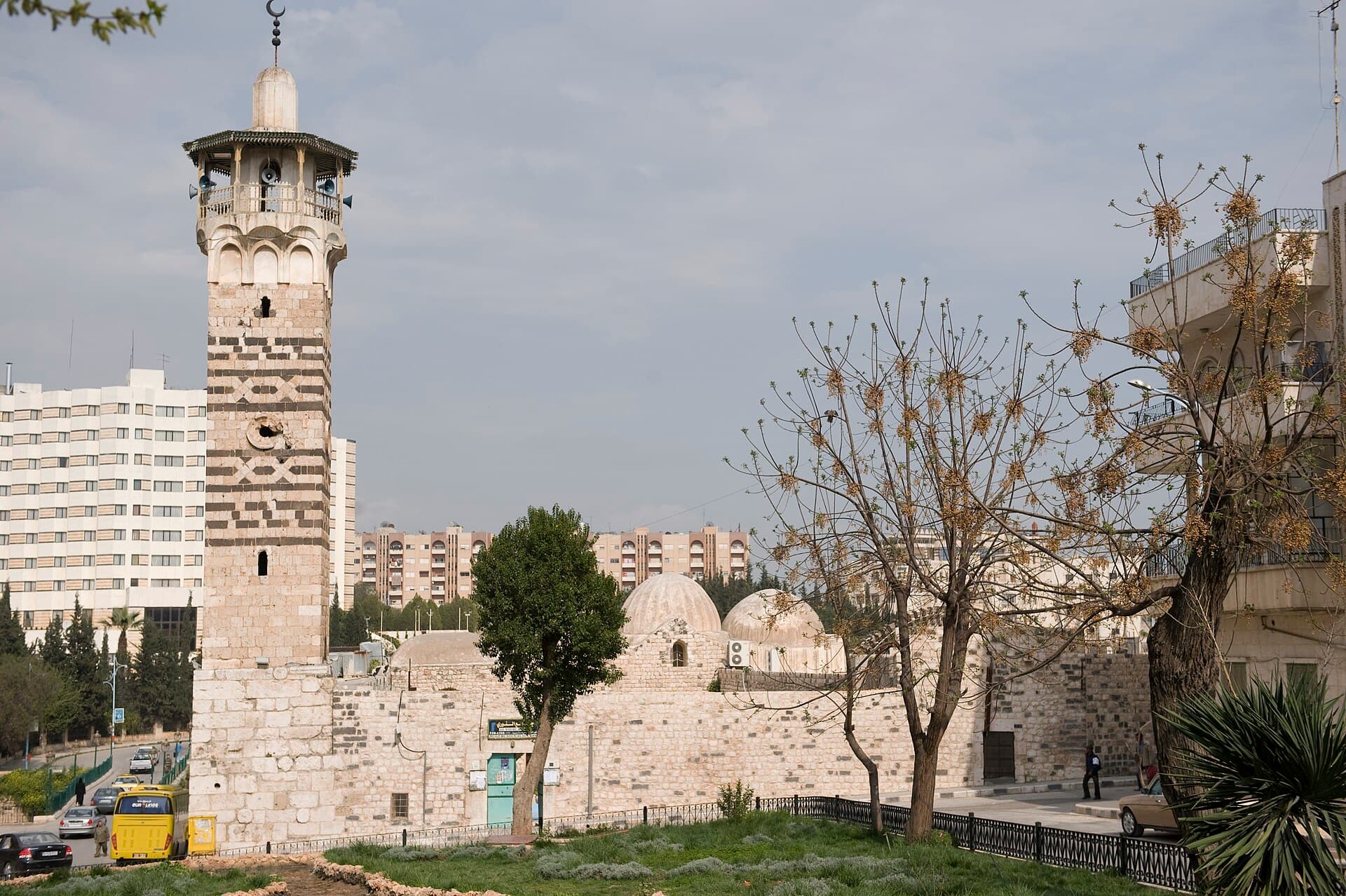 Hama Nuri Camii'nin siyah-beyaz taş desenli kare minaresi ve avlu duvarı