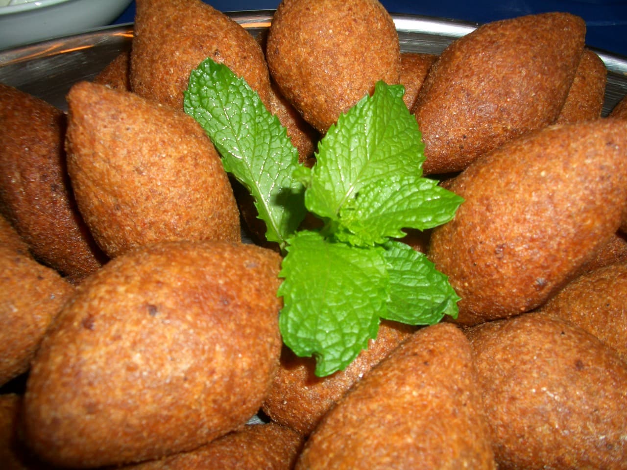 Tepside kızarmış kibbe köfteleri, ortada nane demeti