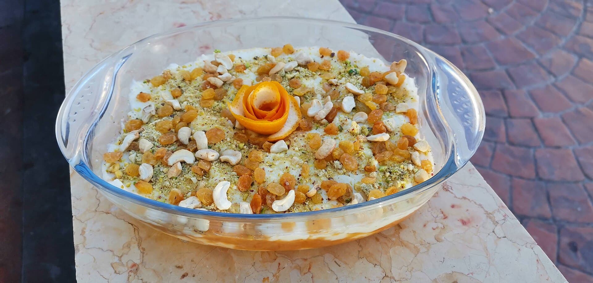Cam kapta ayş es-saraya: altta şerbetli ekmek tabakası, üstünde kaymak katı ve kuruyemiş