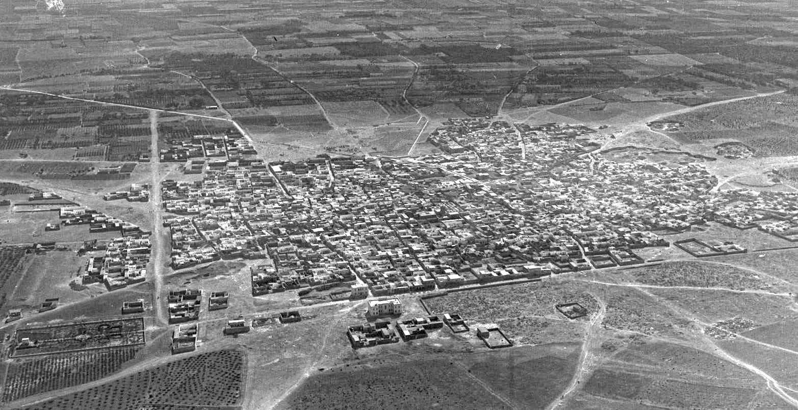 El-Bab'ın 15 Eylül 1934 tarihli eğik hava fotoğrafı: tarla ve bahçelerle çevrili, düz damlı evlerden oluşan sık dokulu kent ve içinden geçen toprak yollar; siyah-beyaz