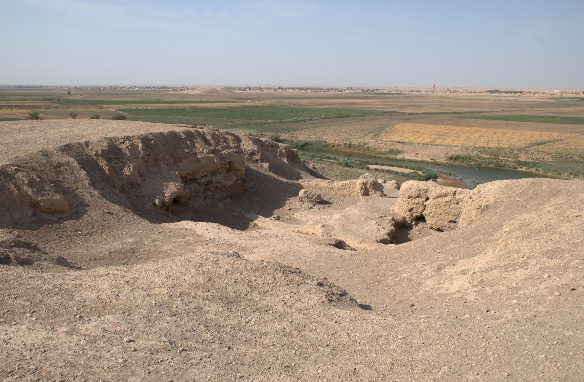 Tell Şeyh Hamad höyüğünün tepesinden kazı açmaları, arkada Habur Nehri'nin yatağı ve vadideki tarlalar