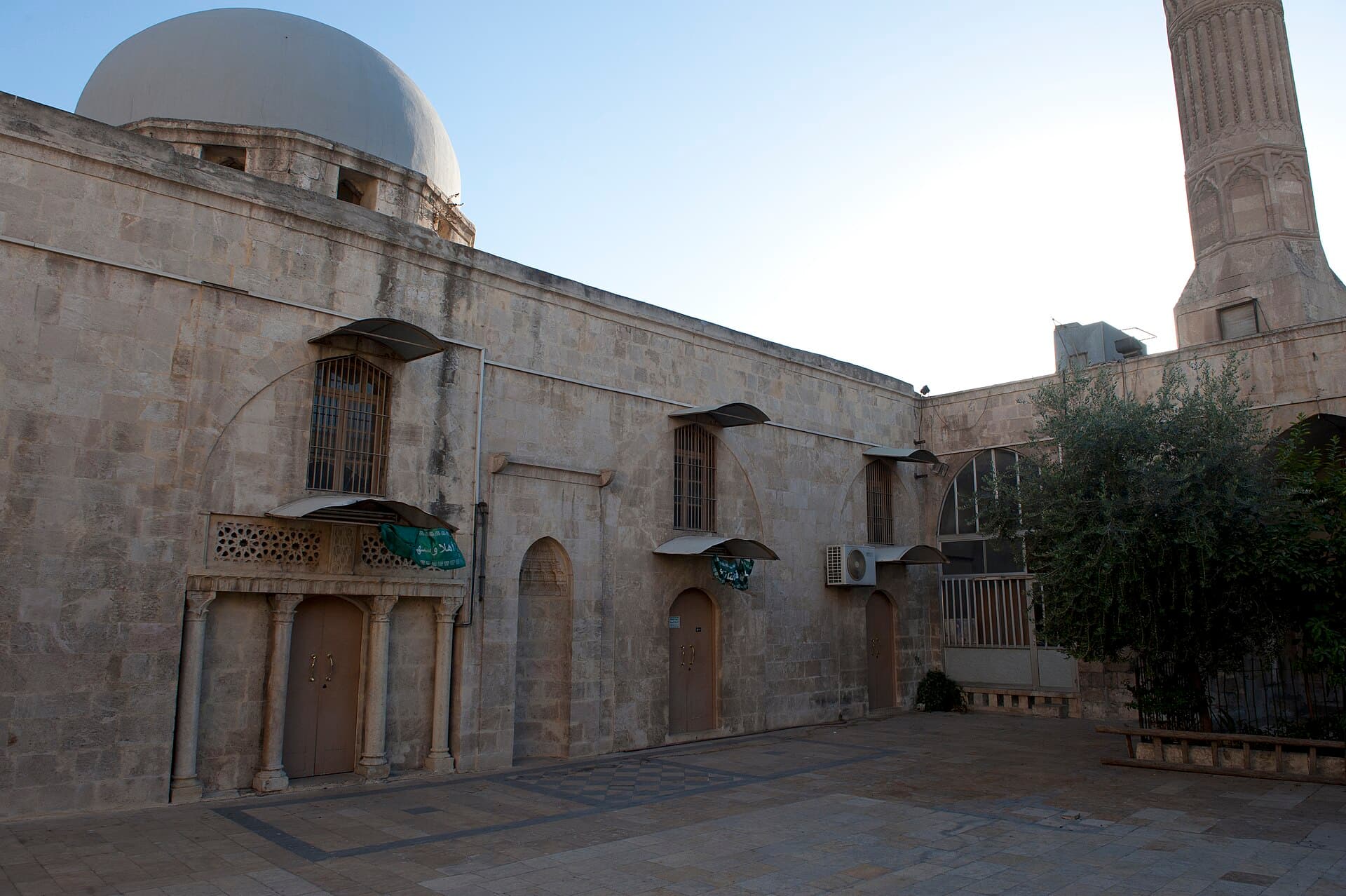Mahmandar Camii'nin avlusu: sütunlara oturan kapı, arkasında kubbe, sağda yivli minarenin gövdesi