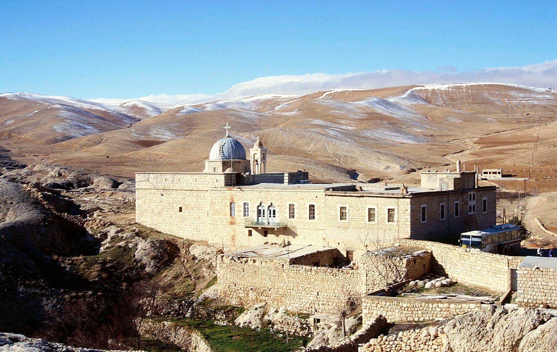 Malula'nın üstündeki kayalıkta kesme taş Mar Serkis Manastırı, arkada karlı Kalamun tepeleri