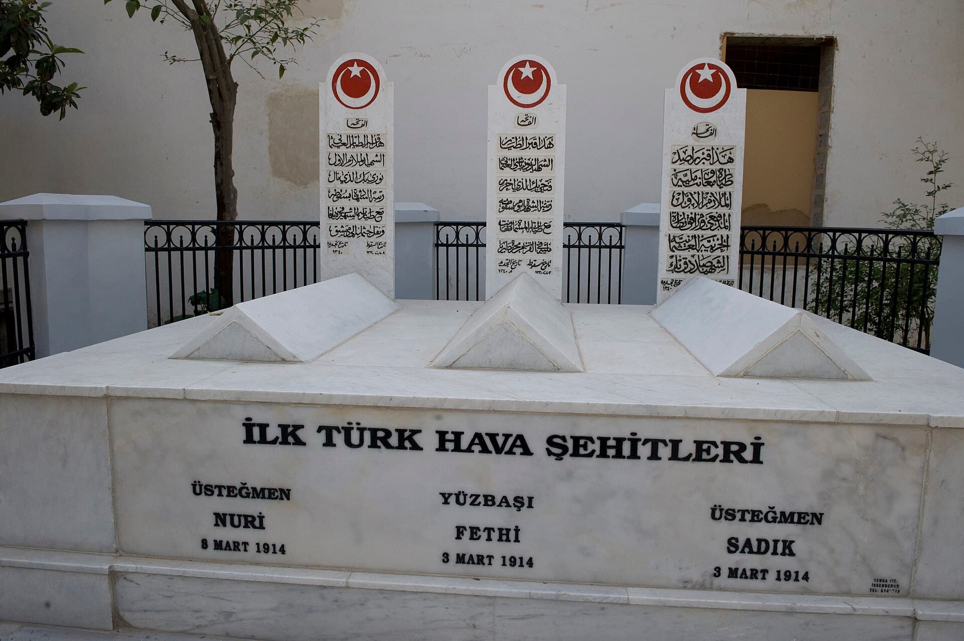 Selahaddin Türbesi avlusunda 'İlk Türk Hava Şehitleri' yazılı mermer seki, üstünde üç lahit ve arkalarında ay-yıldızlı, Arap harfli üç şahide taşı