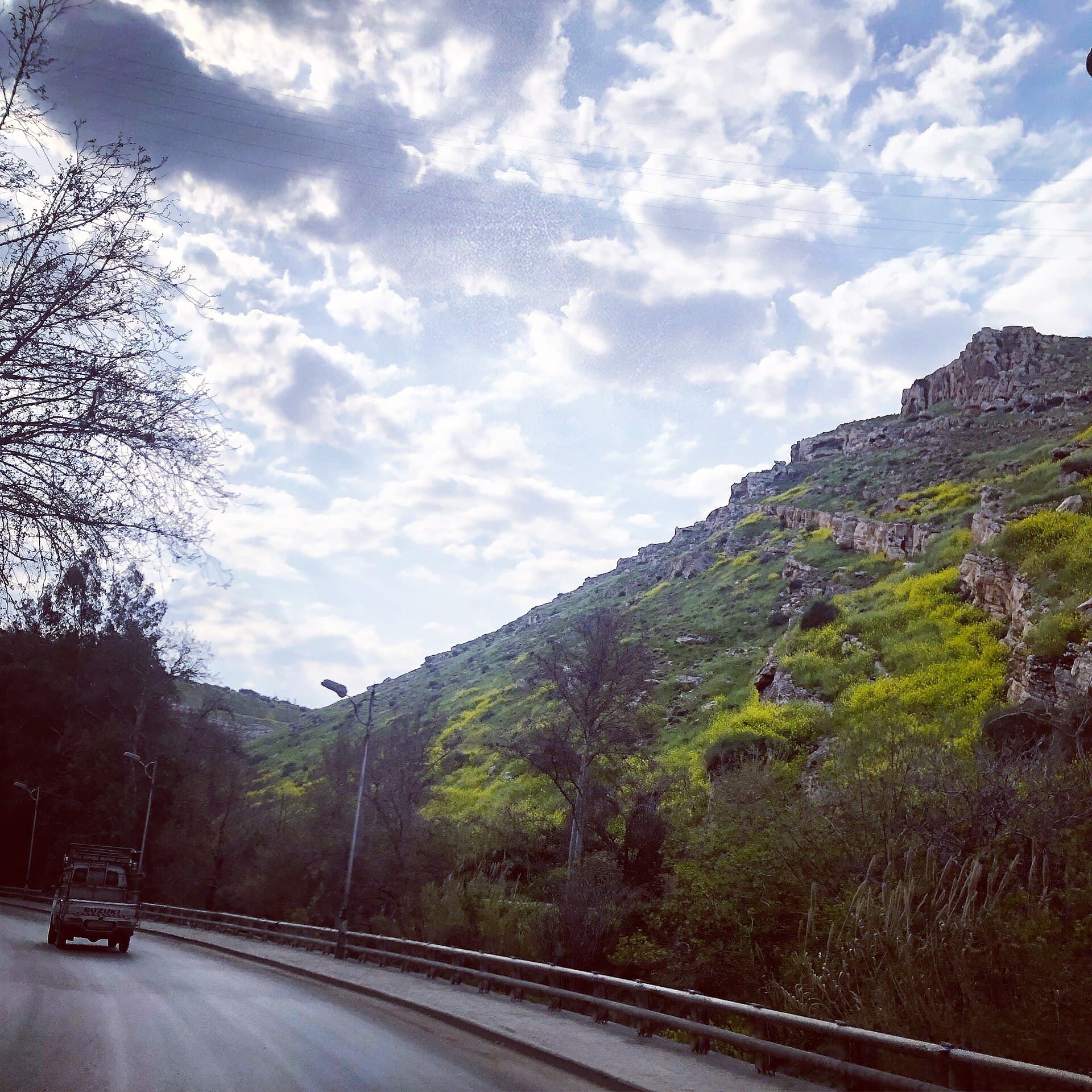 Rabve'de Barada boğazı boyunca uzanan yol ve ilkbaharda sarı çiçekli kayalık yamaç