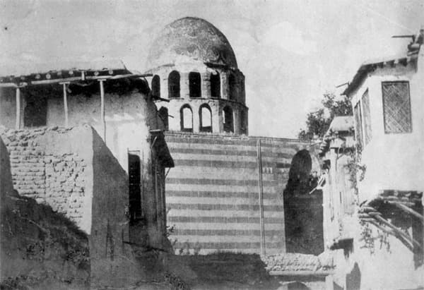 Tavusiyye Camii'nin türbe kubbesi eski bir fotoğrafta: kasnağında iki sıra küçük niş, altında almaşık taş duvar