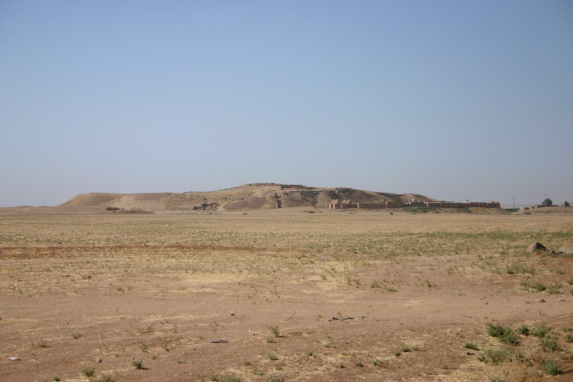 Tell Beydar höyüğü kuzeyden; tepede kazı alanı, eteğinde kubbeli kerpiç kazı evi