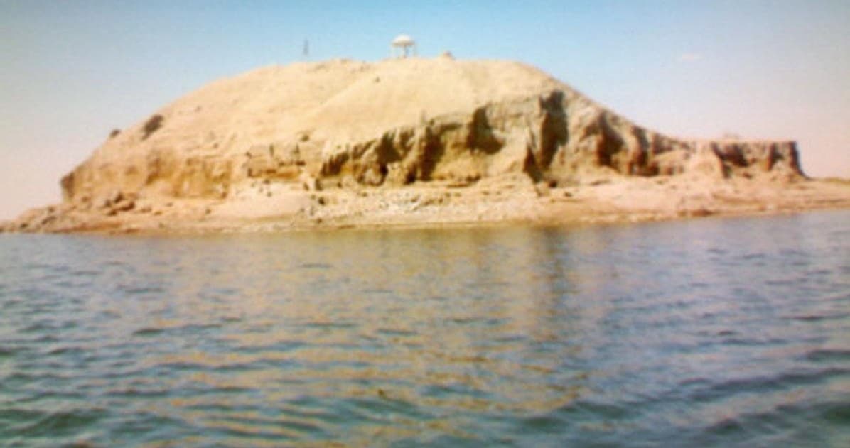 Haseke baraj gölünde ada olarak kalan Tell Taban höyüğü; yamaçları sudan dik yükseliyor, tepede küçük bir gölgelik duruyor