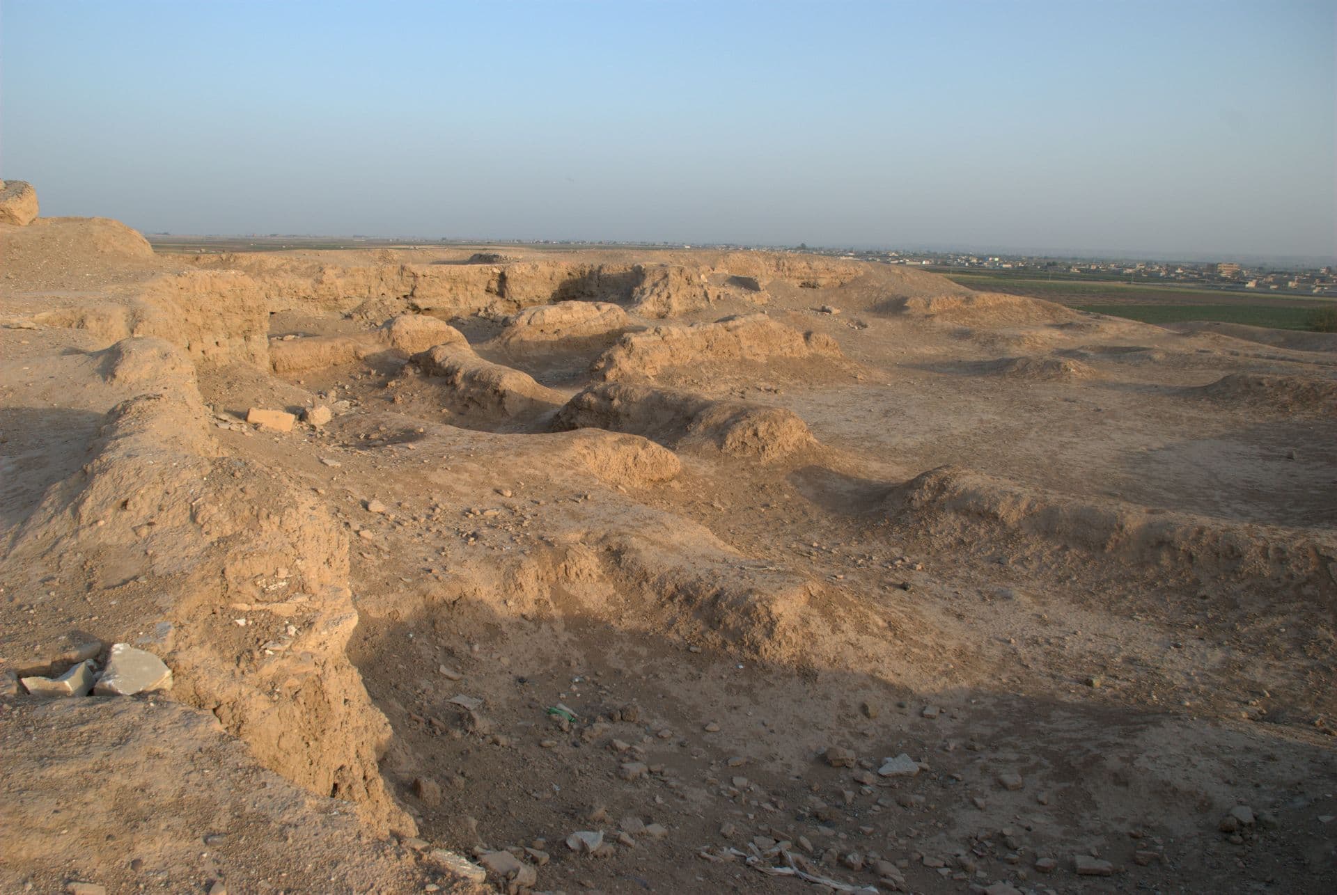 Tuttul höyüğünün kazılmış merkezî tepesi; kerpiç duvar dipleri ve ardında Rakka'nın kenar mahalleleri