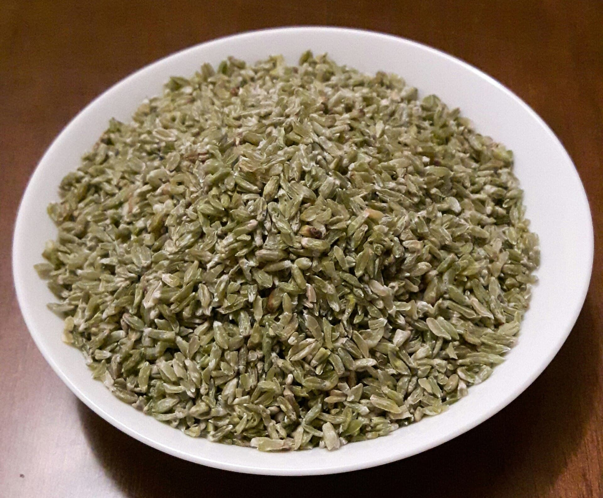 Beyaz kâsede çiğ freekeh; olgunlaşmadan biçilip kavrulmuş yeşil buğday taneleri