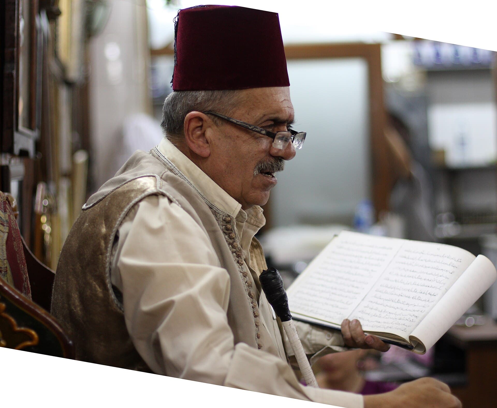 Nevfara Kahvesi'nde hakawati Ebu Şadi, kırmızı fesi ve cüppesiyle kitabından okurken (2010)