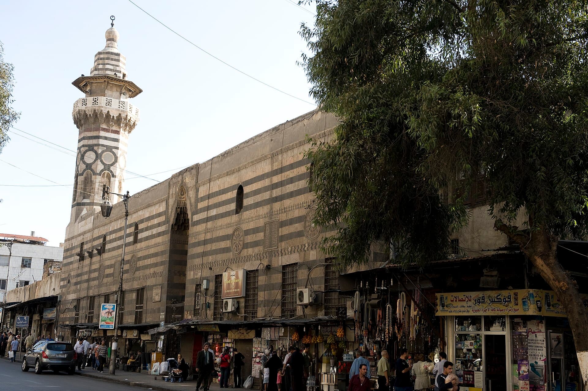 Sibaiye Medresesi'nin şeritli taş cephesi ve gövdesinde siyah halkalar bulunan minaresi