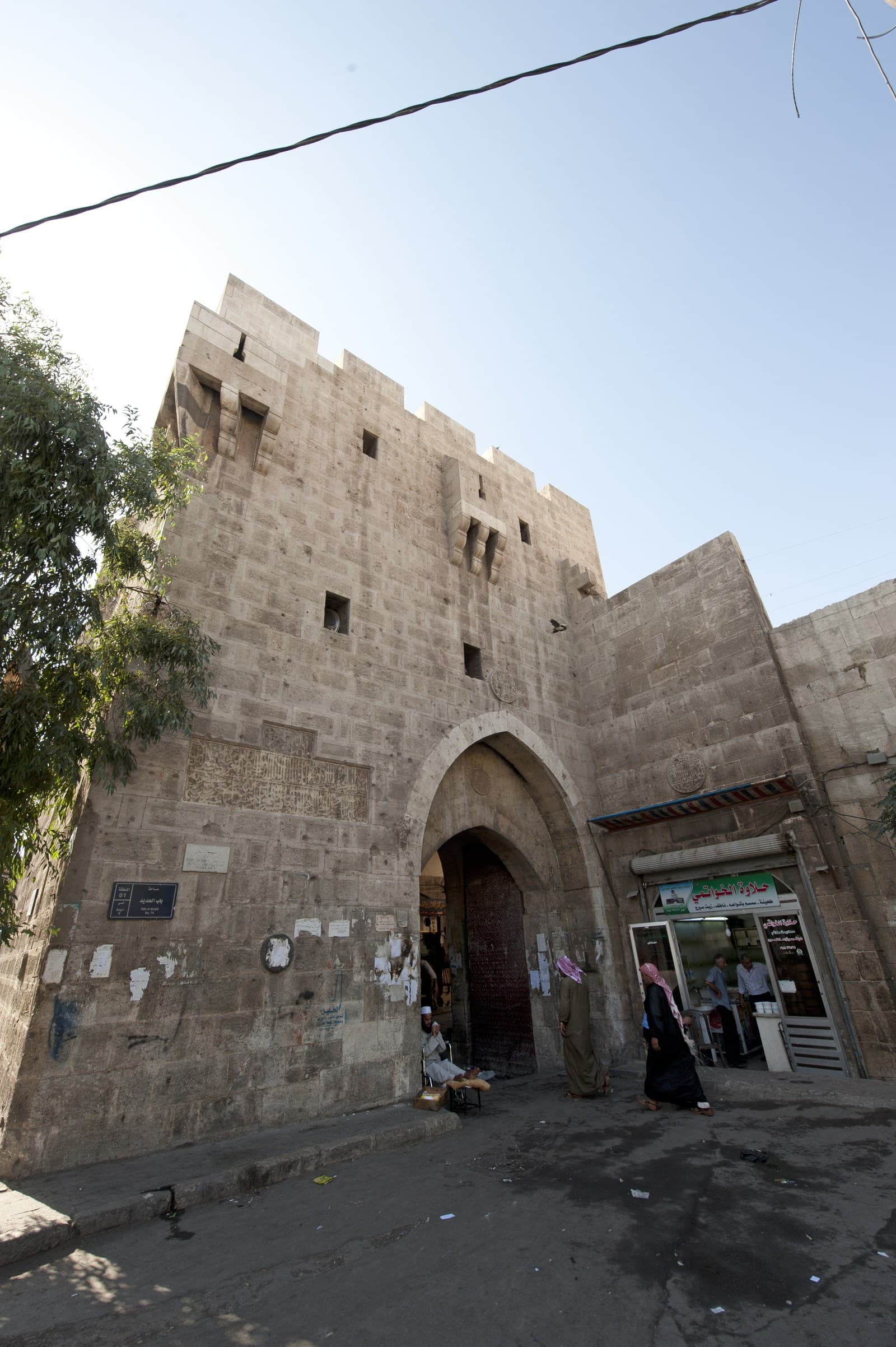 Bab el-Hadid'in iki katlı burcu: mazgal dişleri, ok mazgalları, taş çıkmalar ve cephedeki kitabe levhası