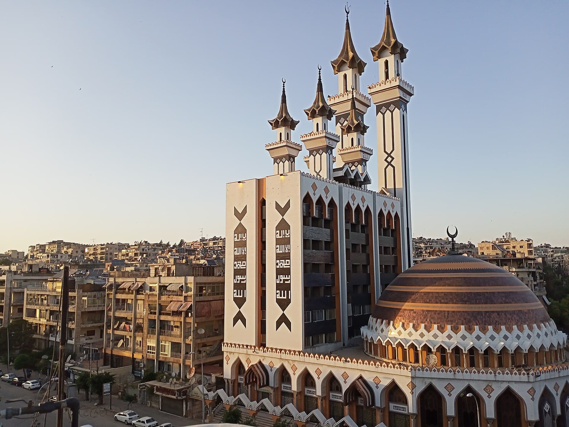 Halep'te Rahman Camii'nin bakır tonlu kubbesi, kare gövdeli minareleri ve Kuran sayfası biçiminde taş panolarla kaplı dış duvarı