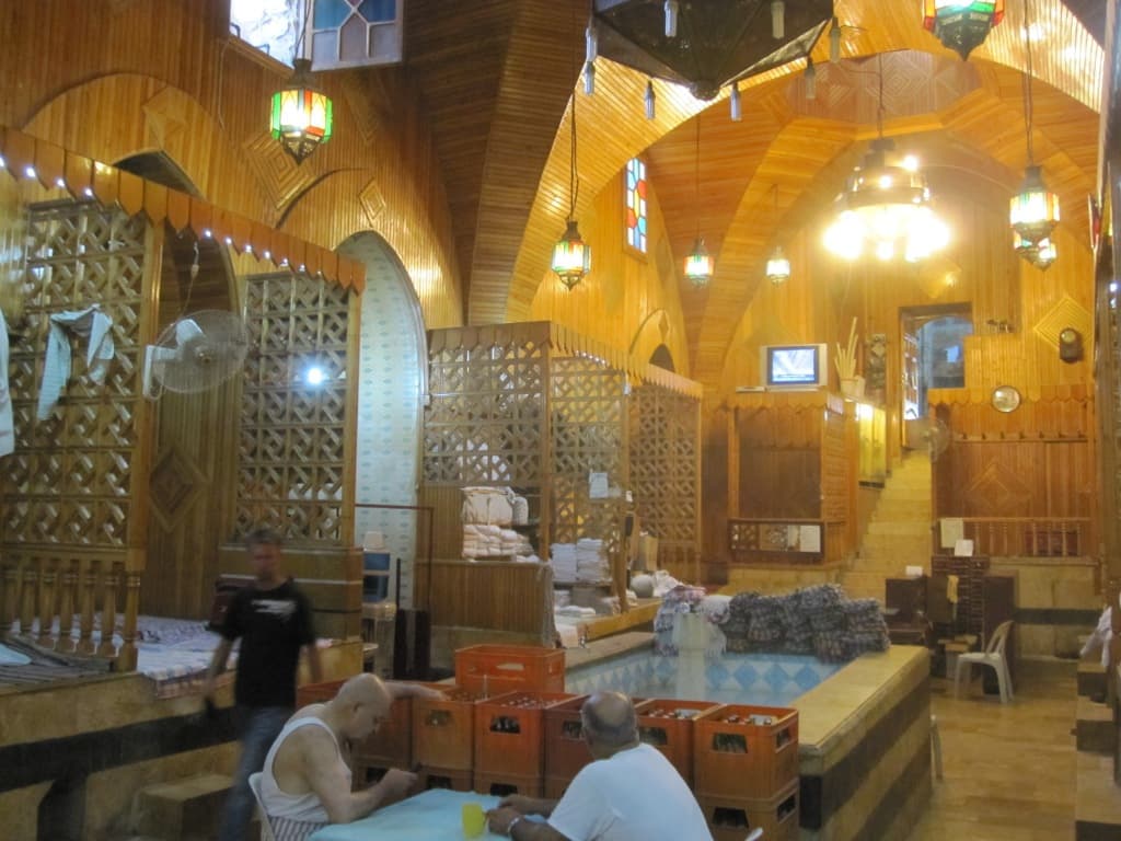 Hamam en-Nahhasin'in dış bölümü: ahşap kaplı tonozlu tavan, renkli cam fenerler ve ortadaki havuz (2010)