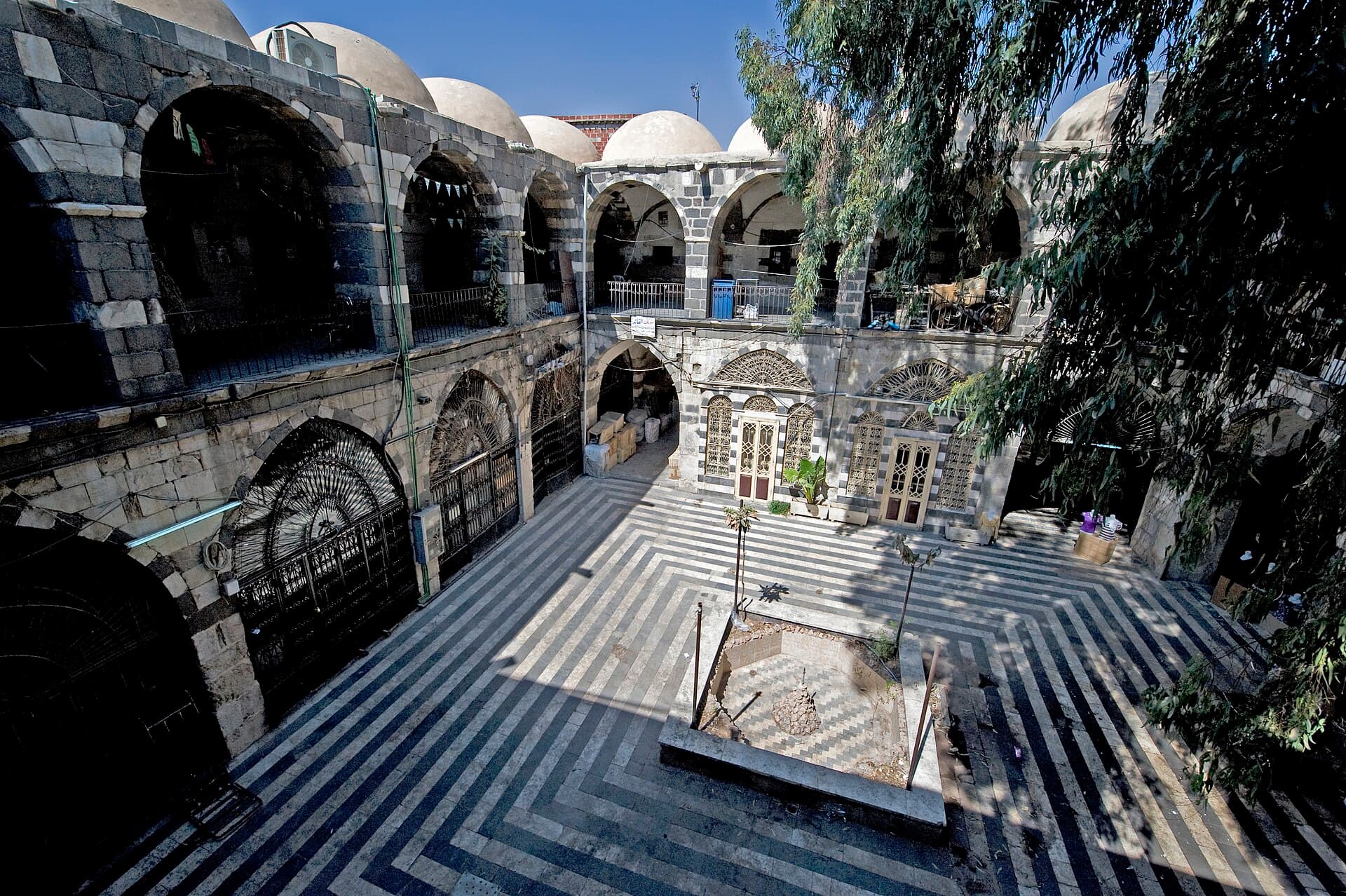 Han ez-Zeyt'in siyah-beyaz taş şeritli iki katlı avlusu, üstte sıra sıra kubbeler