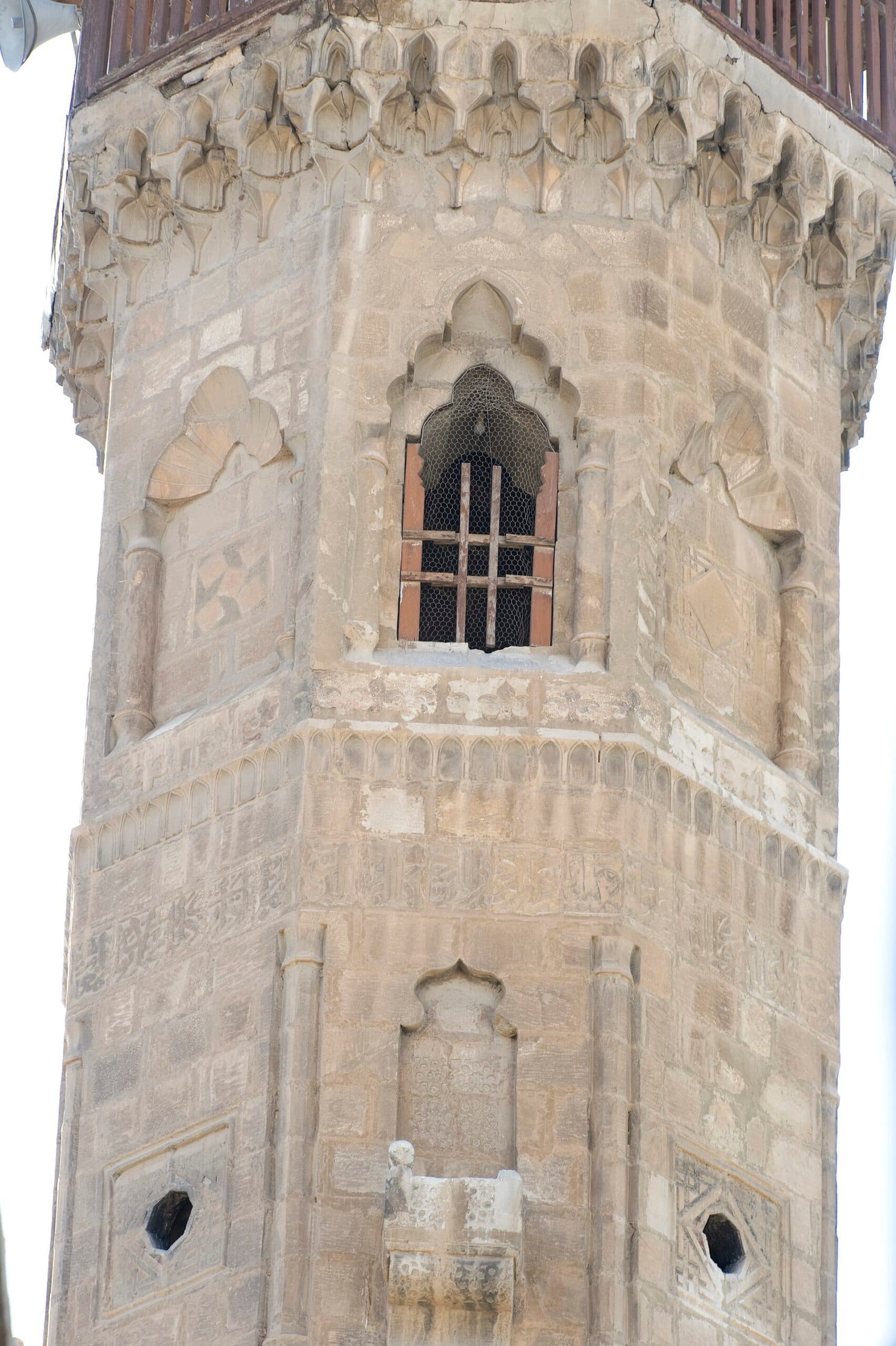 Hişam bin Ammar Camii'nin sekizgen minaresi; oyma yazı kuşağı, mukarnas sırası ve demir kafesli pencere