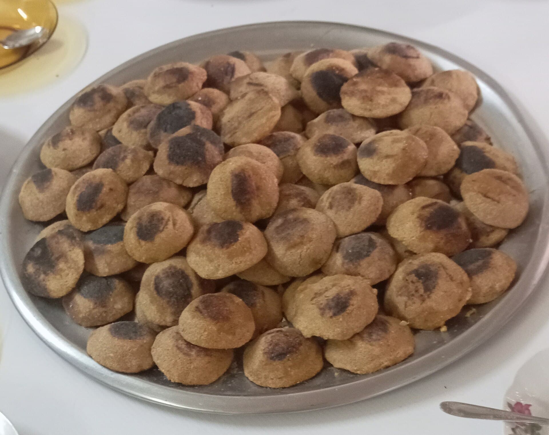 Metal bir tepsiye dizilmiş, üstleri kömür ateşinden yer yer kararmış yuvarlak ızgara kibbe diskleri