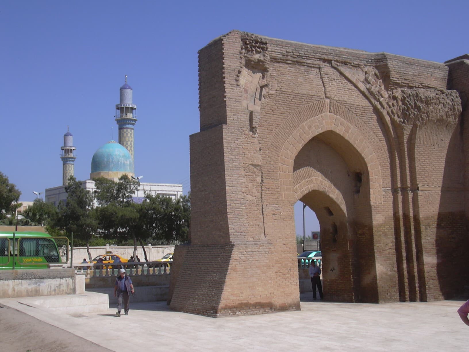 Rakka'da Bab Bağdad'ın tuğla cephesi ve kırık kemeri; arkada 2014'te yıkılan Üveys el-Karanî Camii (2006)