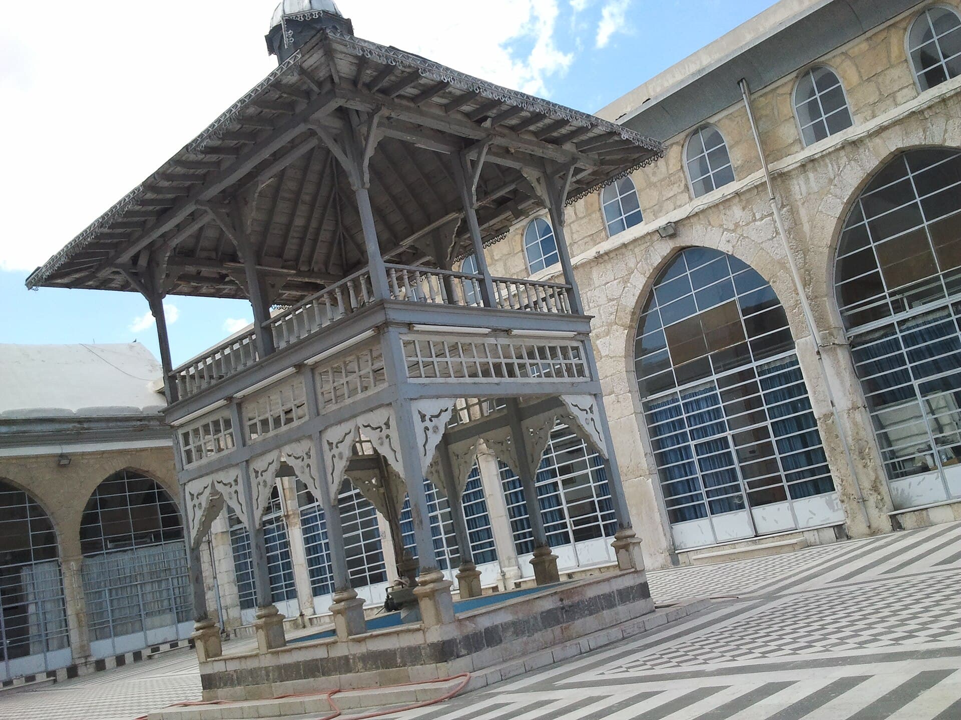 Tevbe Camii avlusundaki ahşap direkli şadırvan köşkü ve siyah-beyaz taş döşeli zemin, Şam